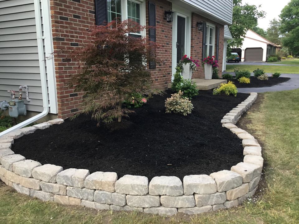 White pavers surrounding black mulch