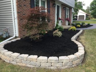 White pavers surrounding black mulch.